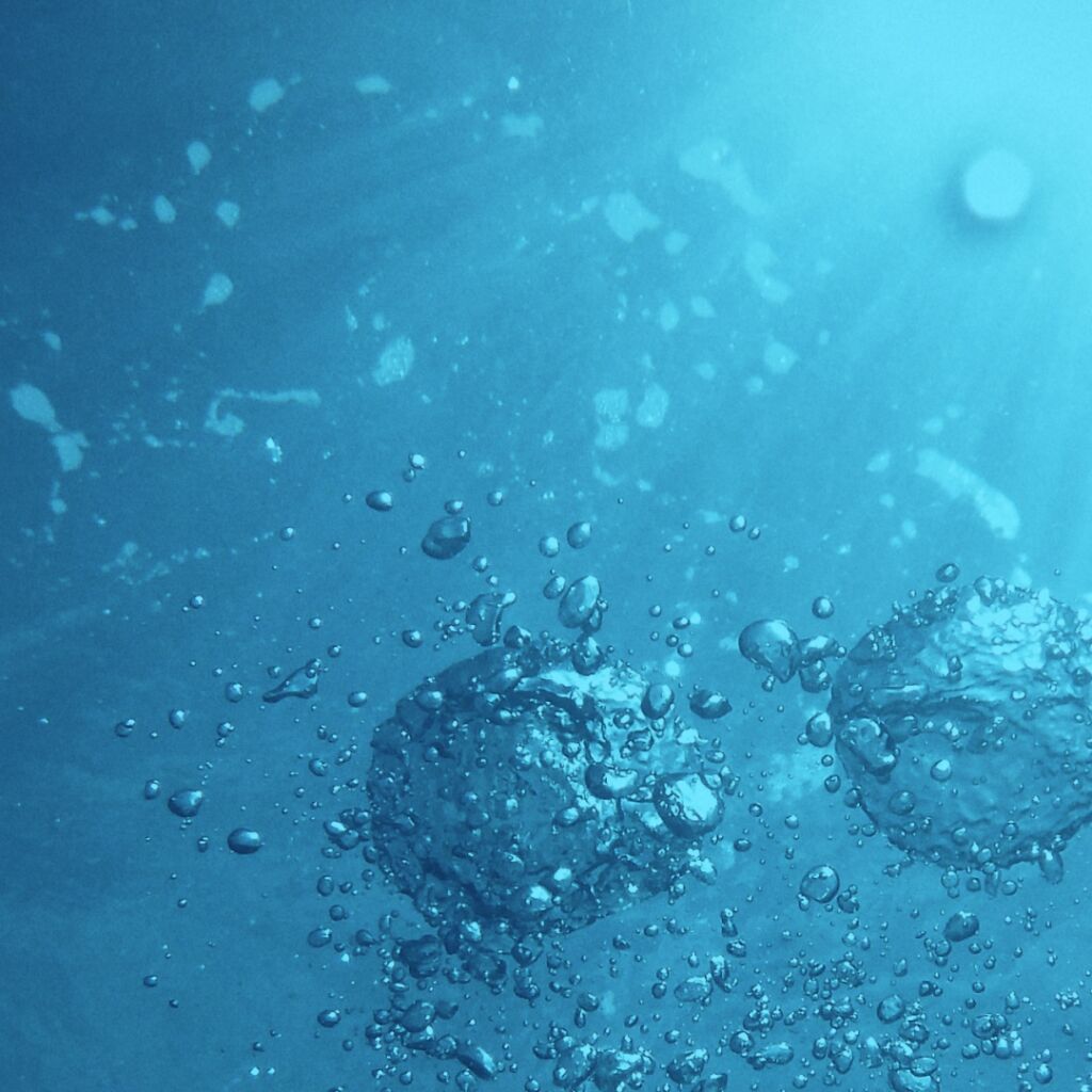 Blue water with bubbles rising to the surface.